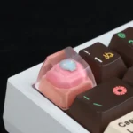 A close-up side view of the whimsical handcrafted pink cat keycap, revealing its adorable luminous resin cat head and charming details.