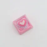 Handcrafted pink heart keycap, showcasing its charming embedded heart in smooth, glossy resin from various angles, a sweet keyboard accent.