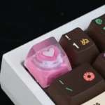 A vibrant close-up of the handcrafted pink heart keycap, revealing its smooth, glossy resin and the charming embedded pink heart, a delightful and unique design.
