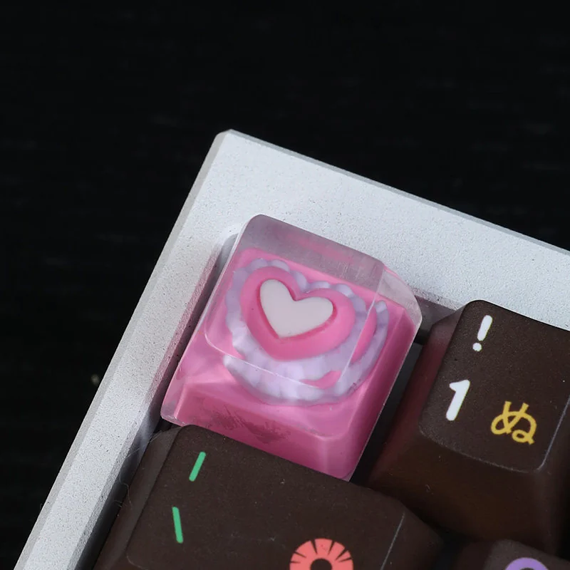 Detailed shot of the handcrafted pink heart keycap's smooth resin surface, revealing the charming embedded pink heart design from a unique angle.