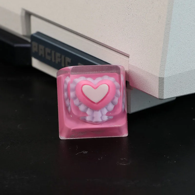 Handcrafted pink heart keycap, a charming artisan resin keycap featuring a sweet, glossy embedded pink heart, perfect for a playful keyboard accent.