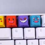 Artistic collection of handcrafted resin Bulbasaur and Charmander Pokemon keycaps from various angles, emphasizing their vibrant details and unique art design.