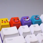 Vibrant handcrafted resin Pokemon keycaps featuring Bulbasaur and Charmander, showcasing intricate details from multiple angles, perfect for collector.