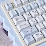 A collection of whimsical blue rain PBT keycaps set from various angles, showcasing adorable cartoon designs and vibrant colors, perfect for a playful keyboard.