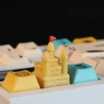 Artisanal 3D sandcastle resin keycap from various angles, revealing intricate sculpting, serene beach details, and the joy of a miniature dreamscape.