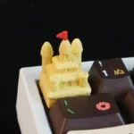 Intricately sculpted Sandcastle Artisan Keycaps, featuring a vibrant yellow sand dune castle, evoking serene beach dreams.