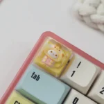 Close-up of the handcrafted Sanrio pajama ESC keycap, revealing a cute character nestled in cozy sleepwear, cast in vibrant epoxy resin art.