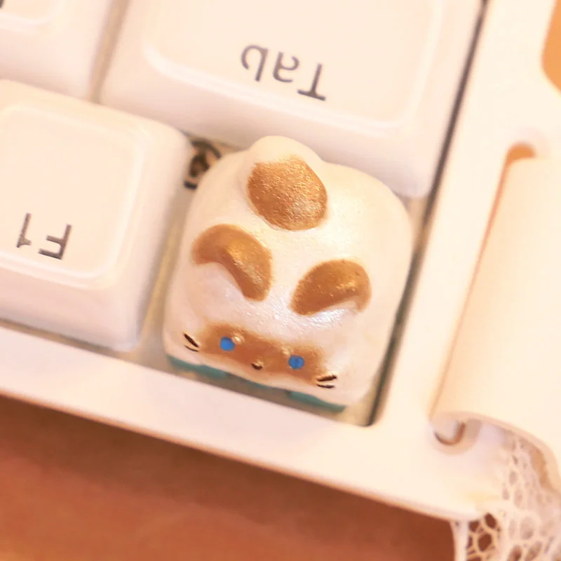 Detailed view of a charming handcrafted Siamese cat keycap, showcasing its intricate artisan design and whimsical kitten features from various angles.