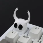 A collection of Hollow Knight The Knight artisan resin keycaps, handcrafted with exquisite dark fantasy detail, shown from various angles.