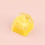 A collection of views of the whimsical handcrafted cheese keycap, showcasing its charming miniature triangle dessert design and unique desk accent.