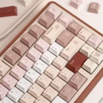 A gallery view of the UR82 Caramel Isle Tri-Mode Mechanical Keyboard, showing its cute milk brown and caramel design from a playful angle.