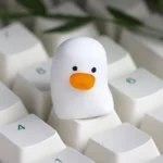 Whimsical resin artisan duck keycap, exquisitely crafted with vibrant colors, displayed from various delightful angles, a charming custom keyboard accent.