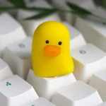 An adorable whimsical duck keycap crafted from smooth, vibrant resin, showcasing its charming artisan details from multiple playful angles.