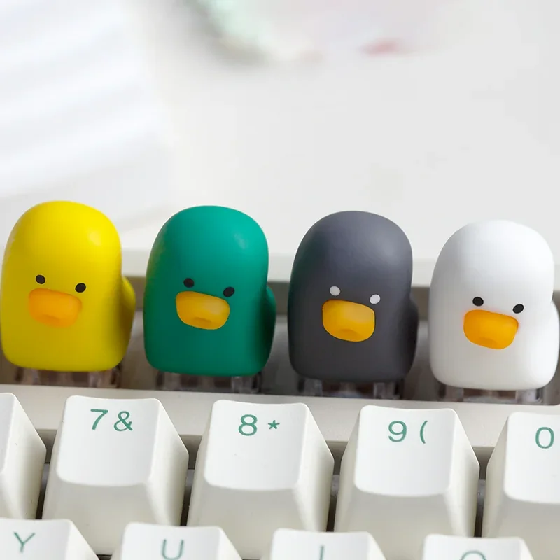 A whimsical, adorable resin duck keycap displayed prominently, showcasing its vibrant colors and smooth artisan finish. This charming duck keycap design.