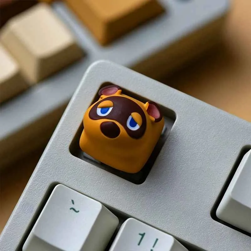 Detailed view of a handcrafted Animal Crossing resin keycap, showing both charming Tom Nook and Isabelle characters from multiple angles.