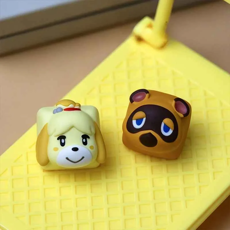 Close-up of a handcrafted Animal Crossing resin keycap featuring Tom Nook and Isabelle, showcasing intricate details from a unique angle."