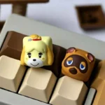 Main image of charming handcrafted Animal Crossing resin keycaps, featuring beloved characters Tom Nook and Isabelle.