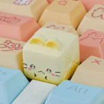 Close-up of a whimsical handcrafted resin Cat Oden artisan keycap, showcasing its adorable miniature food details and vibrant colors.
