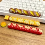 A whimsical artisan spacebar keycap shaped like a detailed, golden baguette, adding a unique, food-inspired touch to mechanical keyboards.