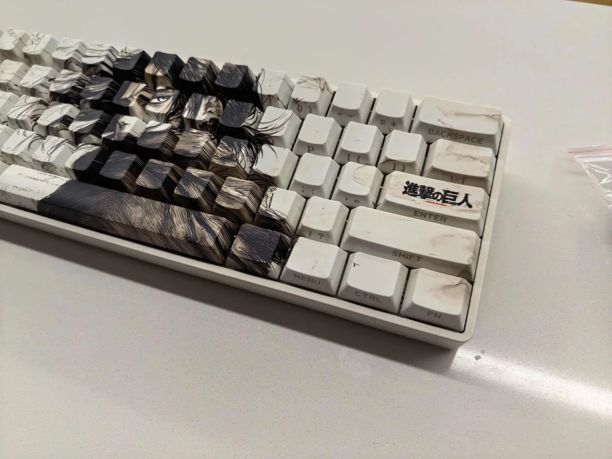 Detailed views of the premium Eren Yeager Attack Titan PBT Keycaps set, showcasing its dark aesthetic, side-printed legends, and exclusive minimalist design.