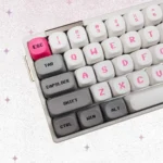 Vibrant pink Bubble Bobble MOA keycaps displaying iconic Bub and Bob characters, capturing playful retro arcade nostalgia from various angles.