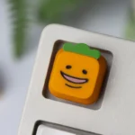 Handcrafted resin Cynical Carrot Tanaka keycaps. Vibrant, detailed characters in various views, highlighting artistry.