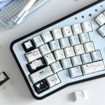 Unique Fake Angel Keycaps PBT dye-sub set, shown from a new angle. Highlights whimsical angelic legends and soft, striking colors with artistic design.