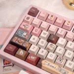 Grand Budapest Keycaps PBT set. Pastel art deco keys with Wes Anderson aesthetic. Close-up shows exclusive vintage travel theme from a unique angle.