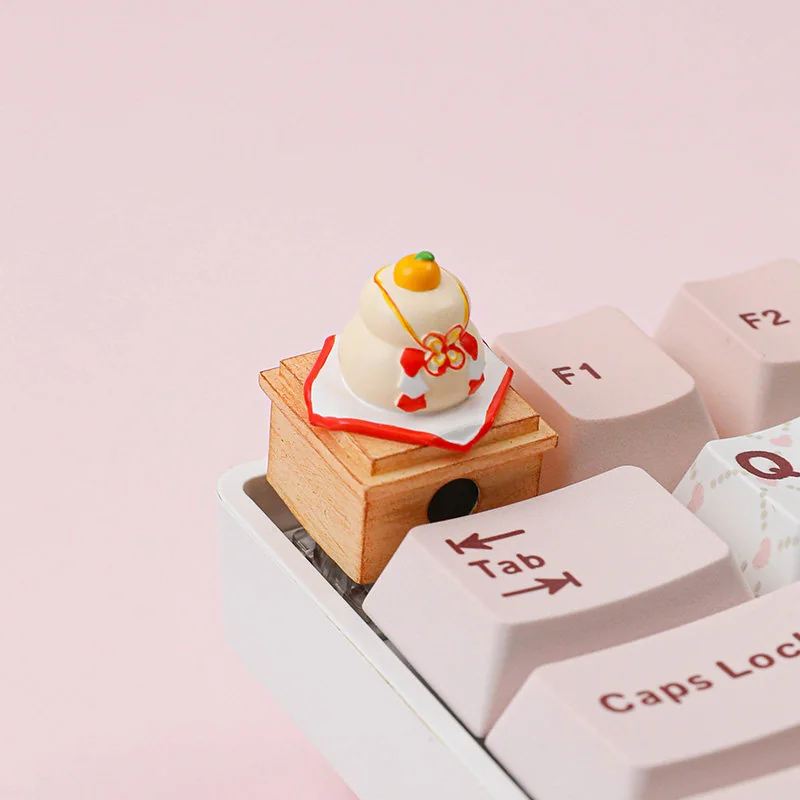 Detailed view of the unique handcrafted Kagami Mochi keycap, showcasing its festive stacked mochi design and vibrant symbolic orange.