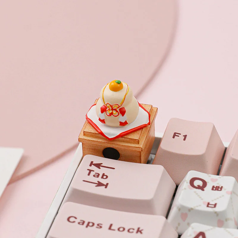 Handcrafted Kagami Mochi keycap, a unique artisan piece featuring traditional stacked mochi and a symbolic orange, perfect for festive keyboards.