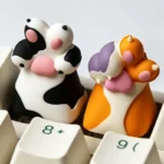 Charming handcrafted resin cat paw keycap for mechanical keyboards, viewed from multiple delightful angles. Adds unique, playful personality.