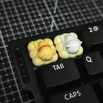 Close-up of a handcrafted resin dog keycap, showcasing the adorable minimalist line art pet design enjoying a tranquil spa moment, adding playful aesthetics.
