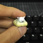 Charming handcrafted resin Maltese dog keycap, featuring minimalist line art of a pet enjoying a tranquil spa, adding a playful touch to keyboards.
