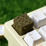 Iconic Minecraft Glowstone Keycap crafted from translucent resin, captured at an engaging angle, highlighting its unique pixelated glow on a gaming keyboard.