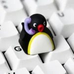 Handcrafted Pingu keycap from multiple angles. Shows vibrant colors, intricate Pingu scenes, whimsical nostalgic charm.