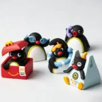 Close-up of a handcrafted Pingu resin artisan keycap, capturing a whimsical claymation scene with vibrant details for a nostalgic keyboard charm.