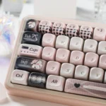 Close-up of pink bandage puppy keycaps, showcasing the charming pastel design and whimsical bandage details from a new angle.