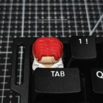 Premium handcrafted ONE PIECE Red-Haired Shanks artisan keycap, showcasing its detailed resin design from a unique angle.