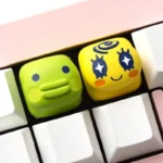 A collection of charming, pixel Tamagotchi keycaps displayed from various angles, highlighting their vibrant colors.