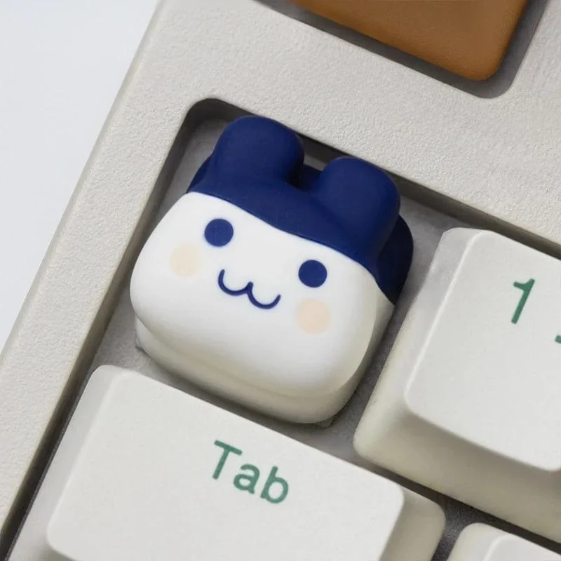 Tamagotchi pixel pet keycap, handcrafted with vibrant details, shown from a playful new angle, enhancing your keyboard charm.