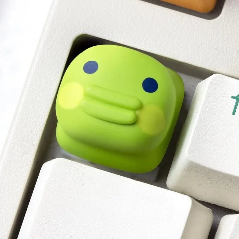 Tamagotchi artisan keycaps from various angles, showcasing vibrant pixel pet designs and charming handcrafted details on mechanical keyboard.