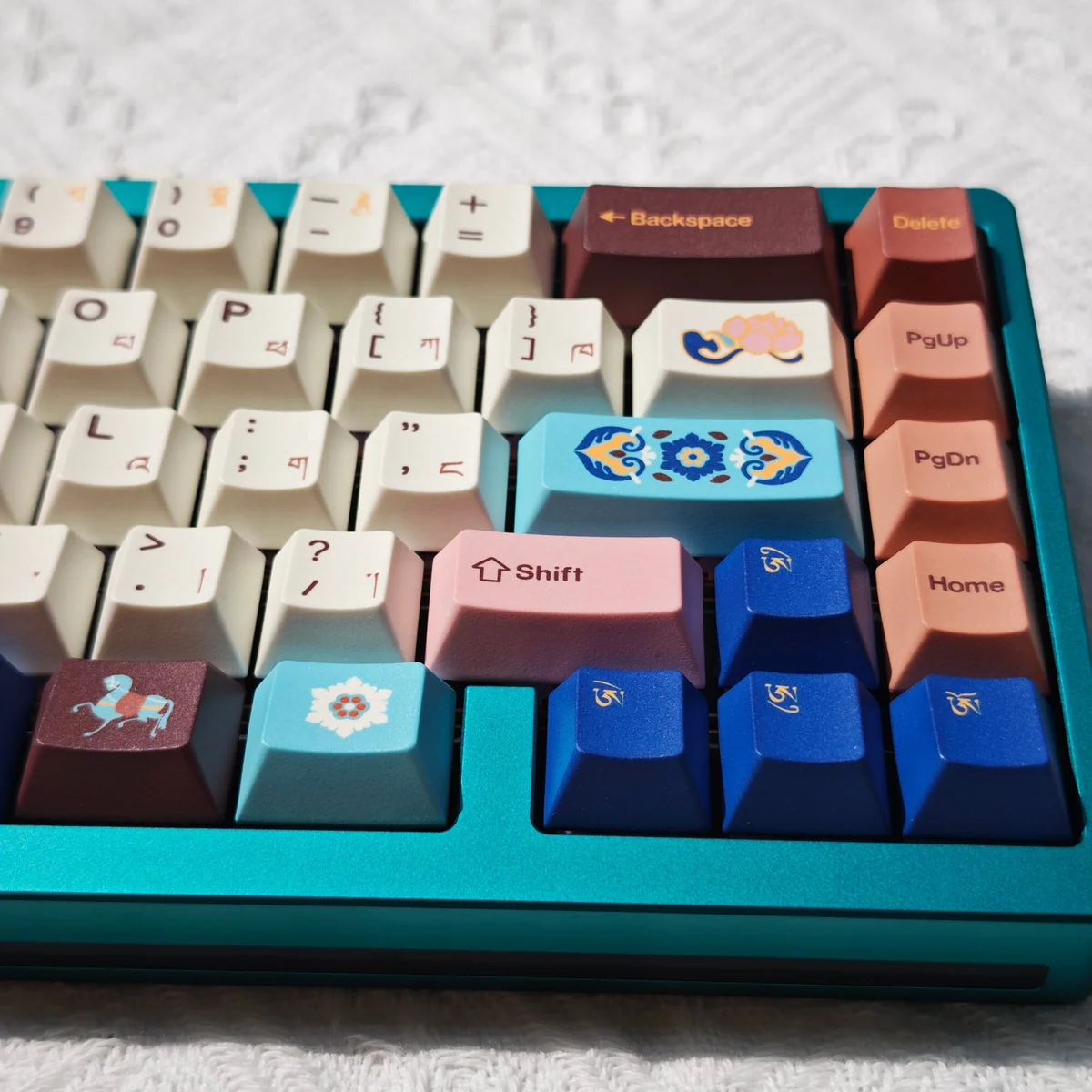 Close-up of vibrant Tibetan Root Letter PBT Dye-Sub keycaps, showcasing intricate Jataka motifs and authentic calligraphy for a serene typing experience.