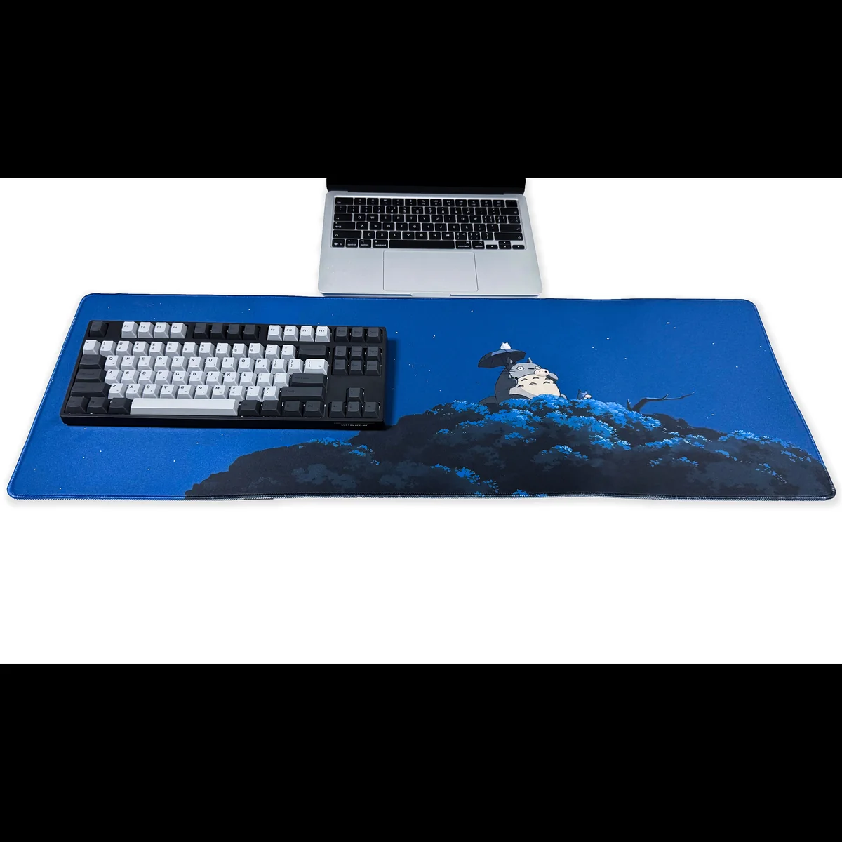 Overhead view of the enchanting Totoro Desk Mat, showcasing its spacious surface with whimsical Studio Ghibli characters nestled in a serene forest.
