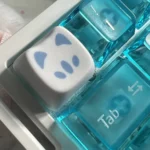 Detailed views of Valorant Omen Kitty PBT keycaps, revealing their sleek, dark design and playful stylized cat ears from various angles.