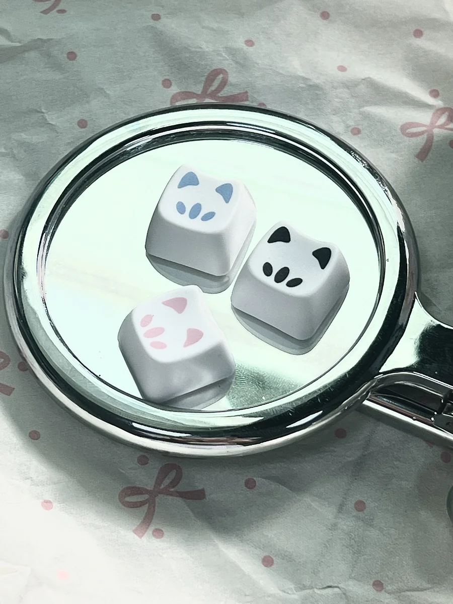 Close-up of a Valorant Omen Kitty PBT keycap, showcasing its sleek design and playful feline accent from multiple angles.
