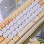 Close-up views of the adorable Rilakkuma & Kaoru PBT Dye-Sub MOA keycap from various angles, highlighting its whimsical pastel design.