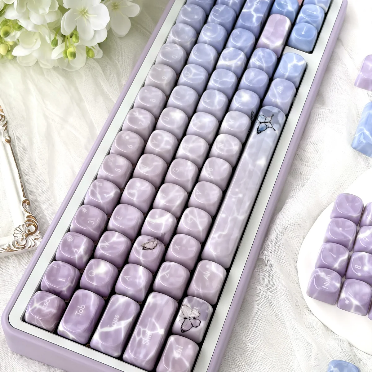 Ethereal butterfly keycaps set, showcasing delicate glimmering designs and a luxurious jade-like feel from multiple angles.