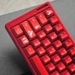 Detailed view of Cola PBT keycaps from various angles, showcasing their vibrant red and white retro metallic finish and iconic dye-sub legends.