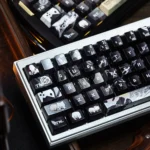 Detailed views of the iconic Final Fantasy VII Sephiroth Cloud PBT side-engraved keycap, showcasing its subtle character motifs and sophisticated metallic finish.