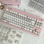 Elegant French Dream PBT MOA keycaps set, shown from multiple angles, highlighting soft pastel hues and delicate vintage French patterns, evoking whimsical design.